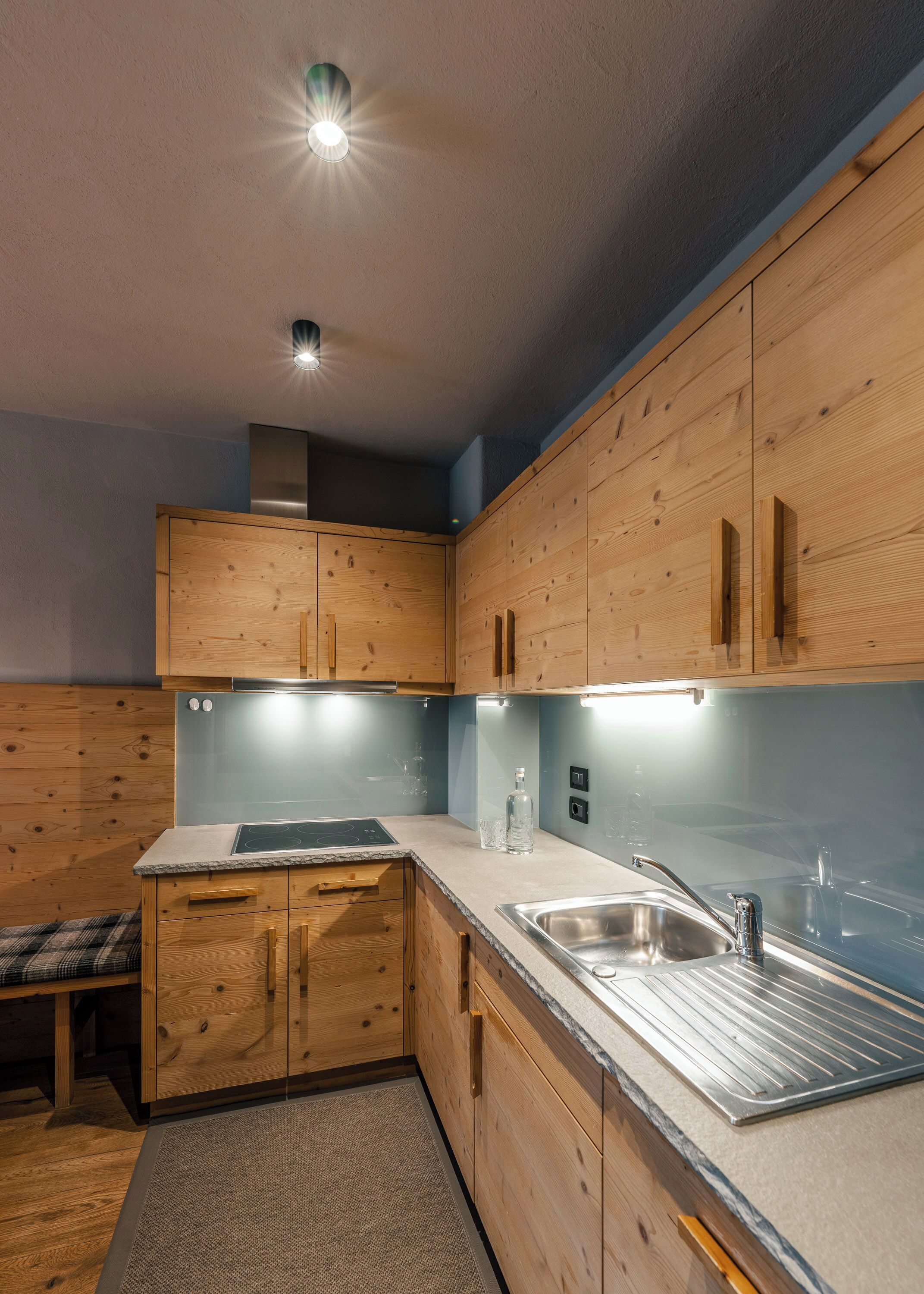A modern kitchen with wooden cabinets, a stainless steel sink, and a built-in stove.