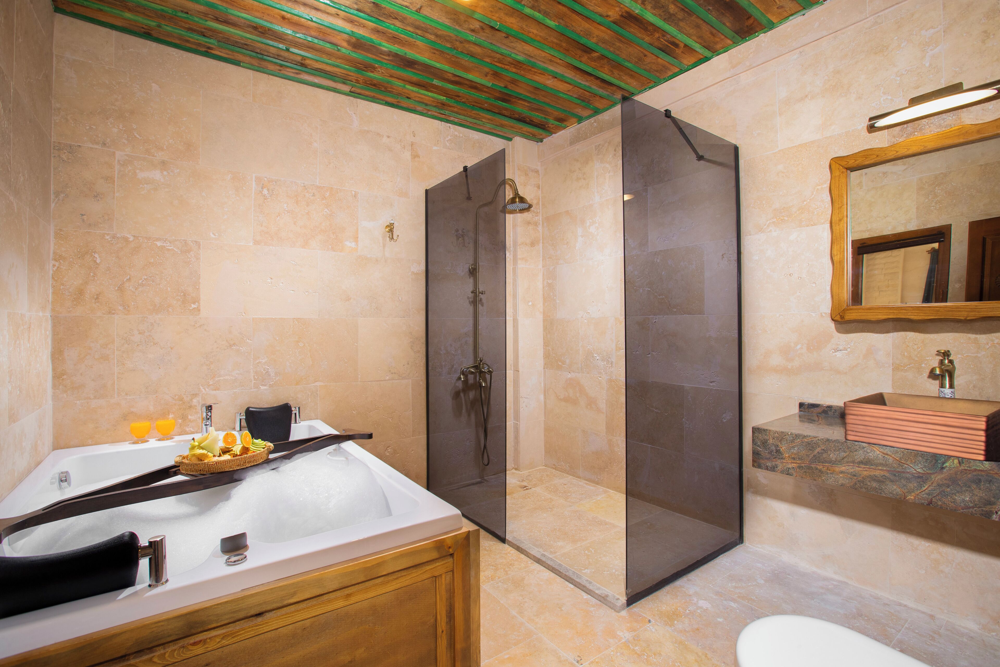 Een moderne badkamer met een vrijstaand bad, een douche met glazen wanden en een wastafel met marmeren blad.
