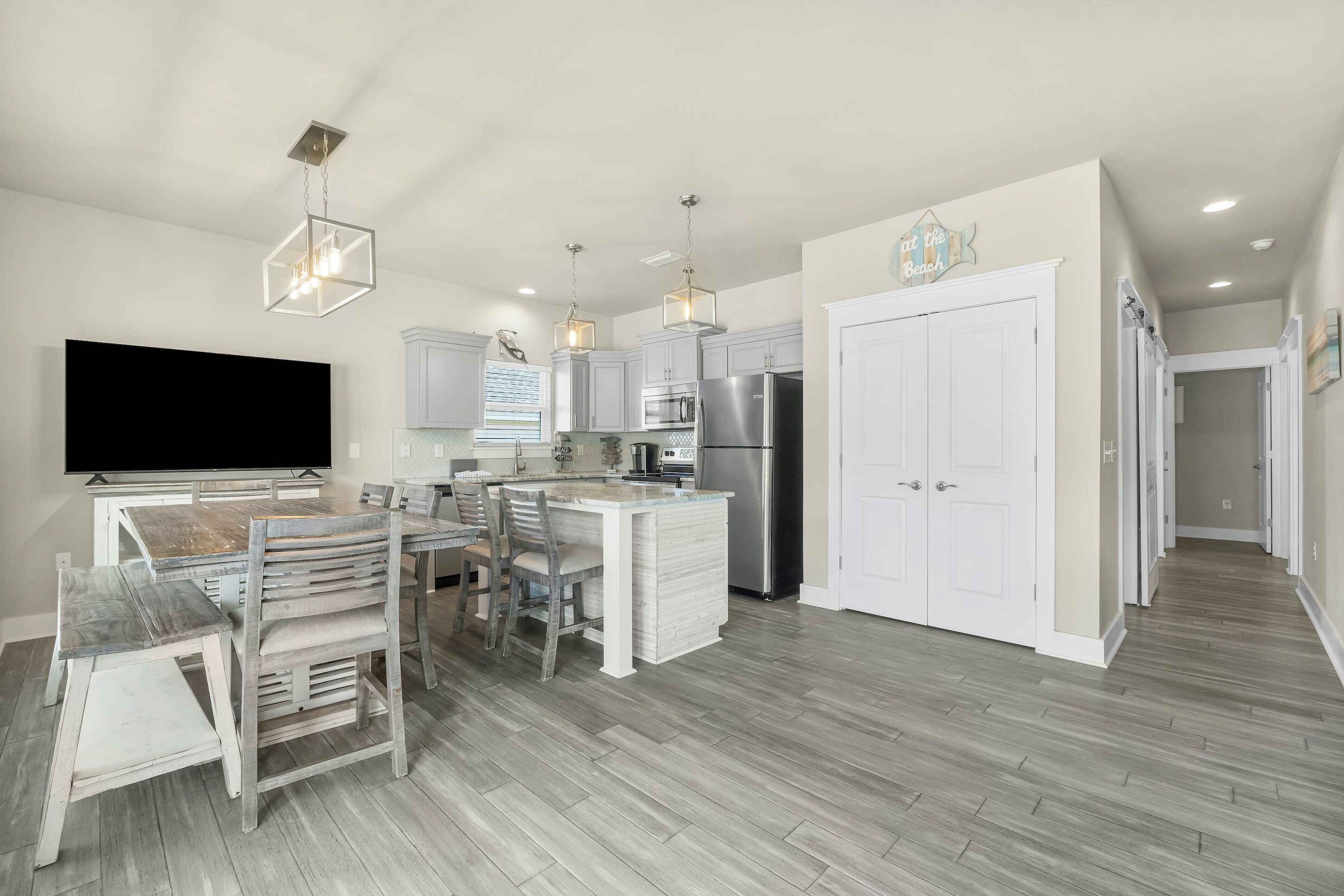 A modern kitchen with a central island, white cabinetry, and stainless steel appliances.