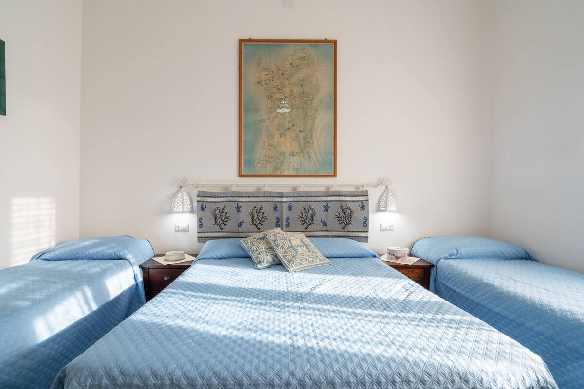 Ein Schlafzimmer mit zwei Betten, einer Karte an der Wand und zwei Nachttischlampen.