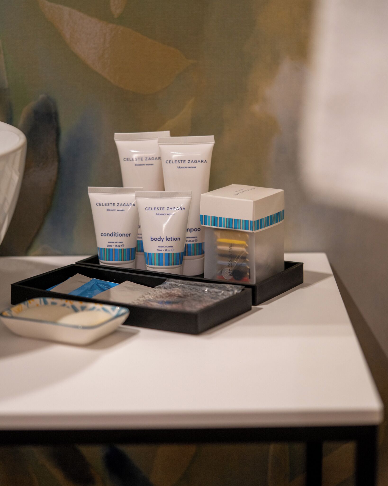 A table with skincare products, including body lotion and conditioner, and a box of shampoo.