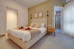 Ein Schlafzimmer mit einem Bett, einem Nachttisch, einer Wandlampe und einer Tür zu einem Badezimmer.