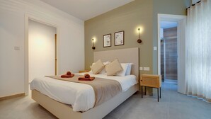 A modern bedroom with a large bed, a bedside table, and a view of a balcony. - Upscale 2BR Apartment by the Promenade (Sliema)