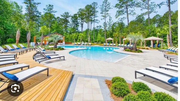 A pool area with lounge chairs and a gazebo.
