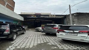 Un área de estacionamiento frente a un edificio con un letrero que dice 'Royal Homestay'.