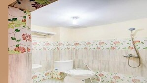 Un baño con inodoro, bidé y ducha.