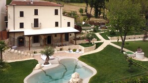 Un bâtiment à deux étages doté d’un patio, d’une piscine et d’un jardin aménagé.