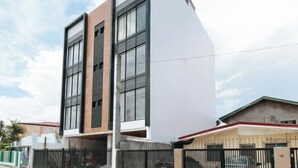 A modern building with a flat roof, large windows, and a brick facade. - RedDoorz @ Good 101 Paranaque (Paranaque)