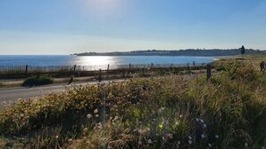 A coastal road with a fence, a clear sky, and a view of the sea. - Duplex apartment with stunning sea view (Guidel)