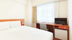 A hotel room with a single bed, a desk with a television, and a small refrigerator. - Comfort Inn Himeji Yumesakibashi (Himeji)