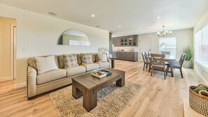En moderne stue med sofa, sofabord og spiseplads.