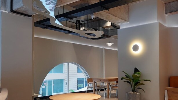 Ein modernes Interieur mit einer gebogenen Bank, einem runden Tisch und einem Blumentopf.