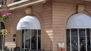 Ein Gebäude mit großen Bogenfenstern und einem Café mit Außenbereich.