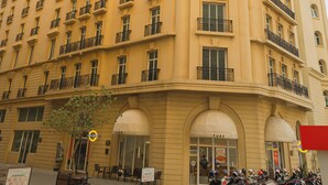Ein mehrstöckiges Hotel mit gelber Fassade, Balkonen und einer Reihe abgestellter Motorräder davor.