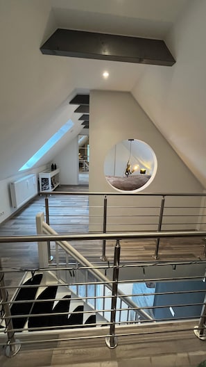 Experience the open and airy atmosphere of this modern space, featuring a spacious area with a skylight and mirror.