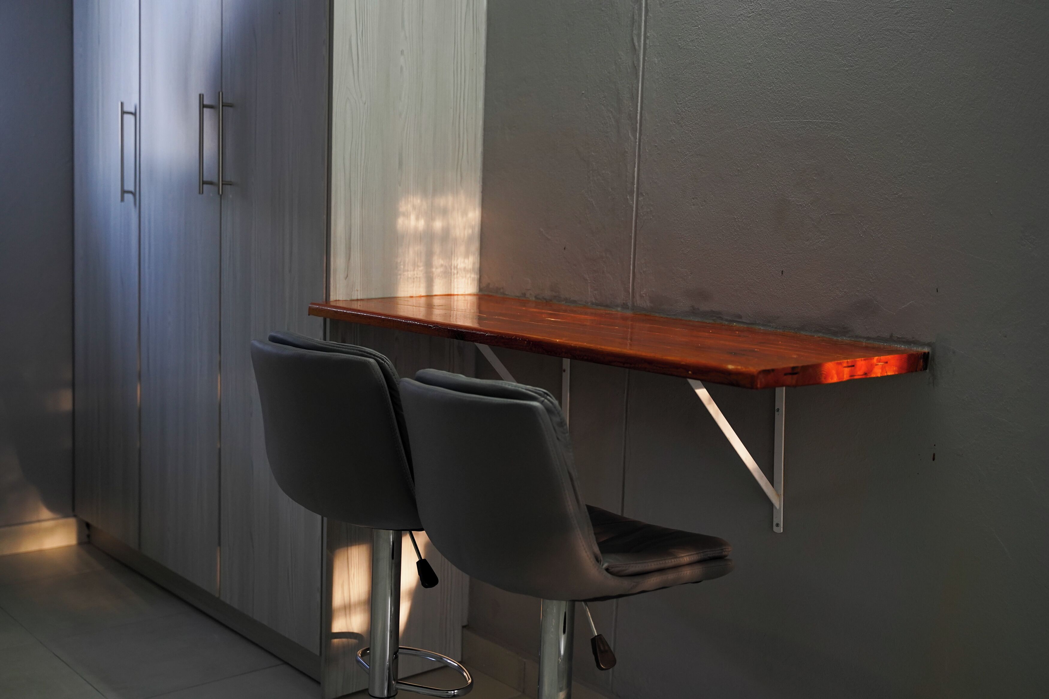 A small kitchenette with a wooden table and two chairs.