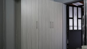 Une pièce dotée d’une grande armoire, d’une porte avec des panneaux en verre dépoli et d’une prise de courant au mur.