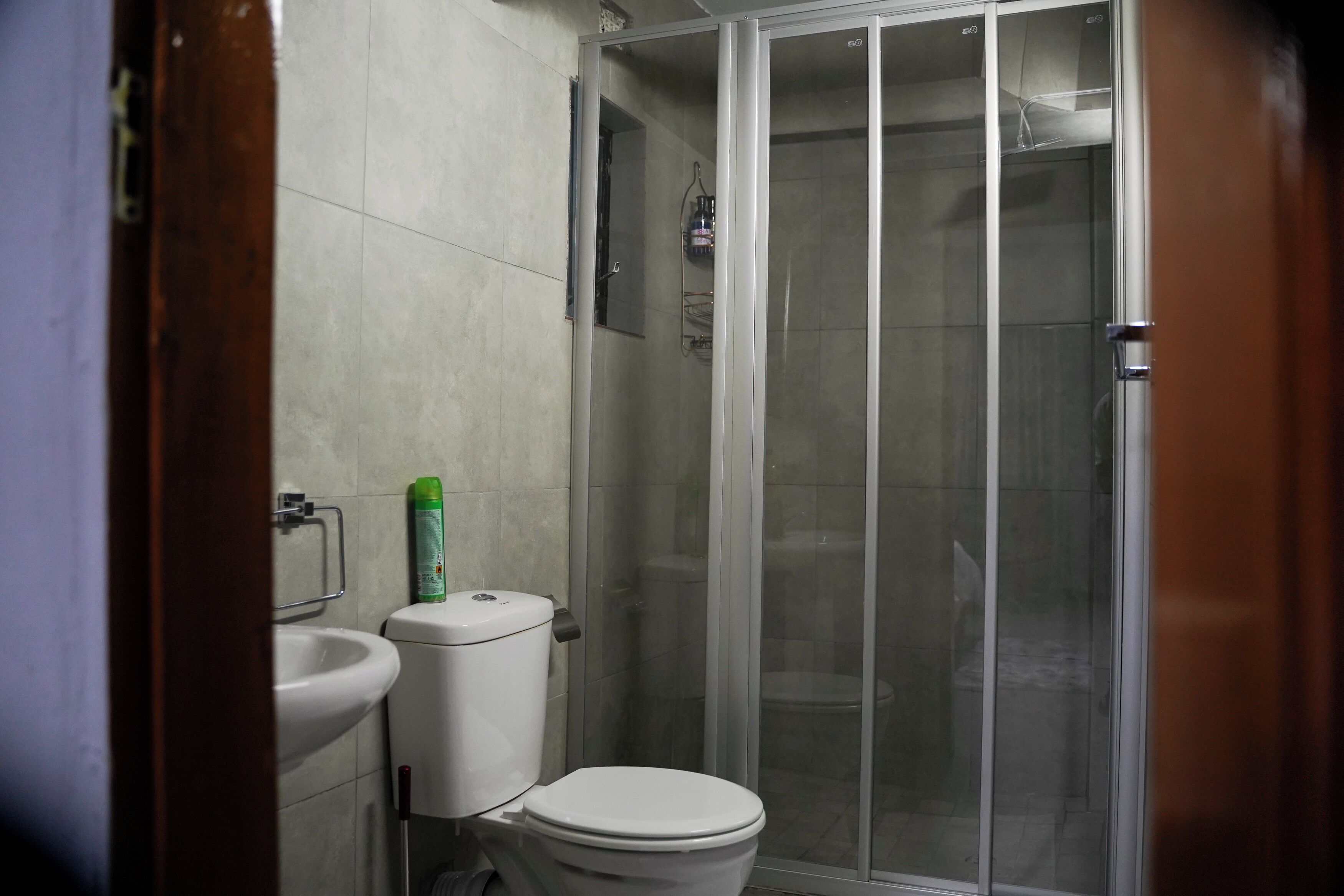 A bathroom with a toilet, sink, and glass-enclosed shower.