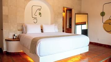 A bedroom with a bed, nightstand, and a wall-mounted artwork.