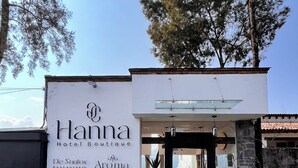 A building with a sign for 'Hanna Hotel Boutique' and 'De Santos Restaurante'.