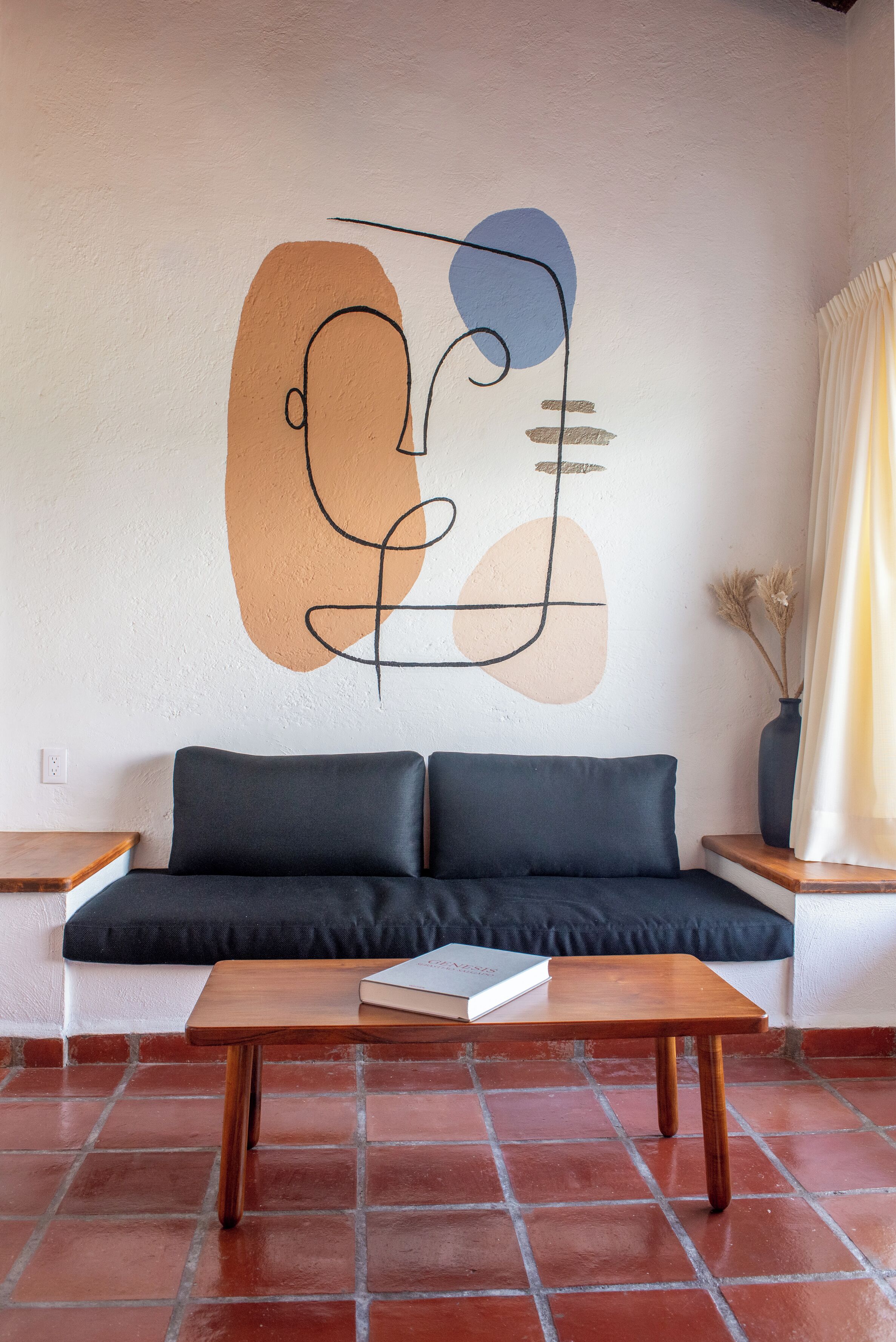 Ein modernes Wohnzimmer mit einer Couch, einem Holztisch und einer Wandmalerei.
