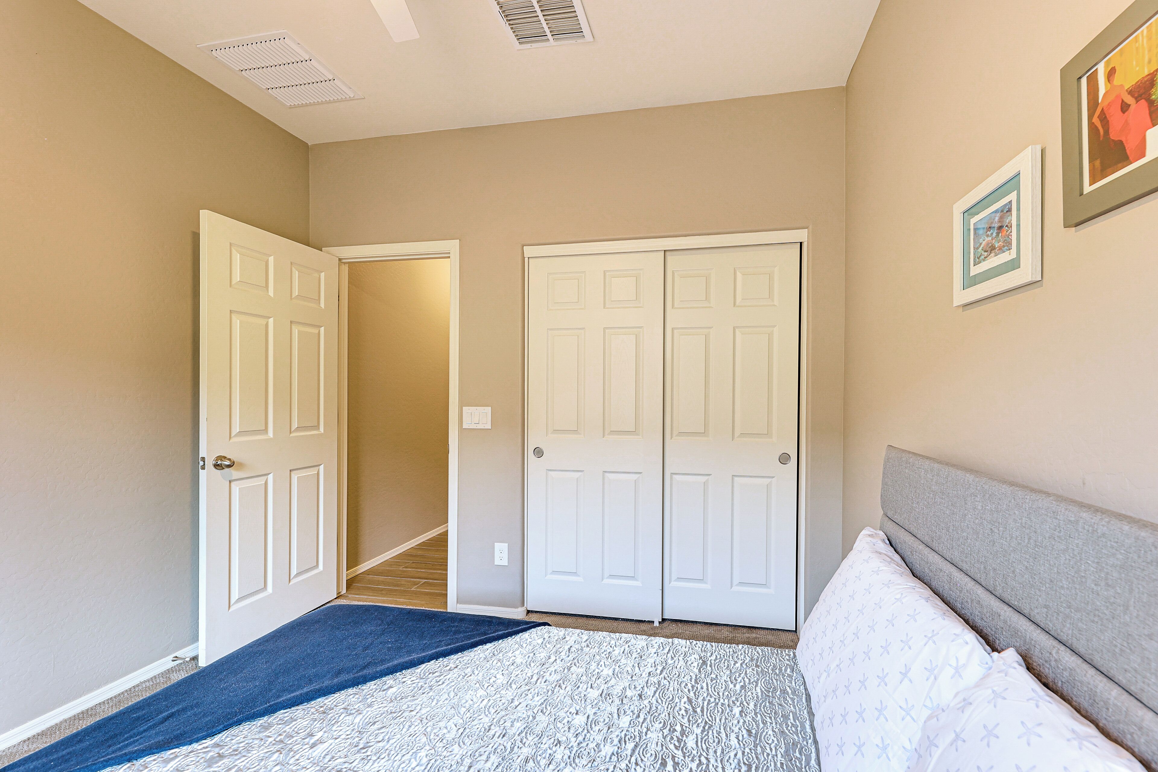A bedroom with a bed, a door, and a hallway.