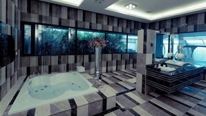 Une salle de bain moderne avec une grande baignoire, un meuble-lavabo avec un miroir et une grande fenêtre.