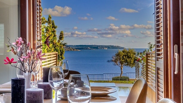 Ein Esstisch mit Meer- und Hügelblick.