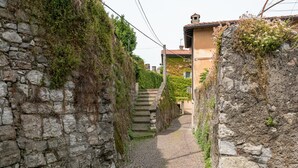 A narrow cobblestone street flanked by stone walls and vegetation. - Campari Aperol in Iseo (Iseo)