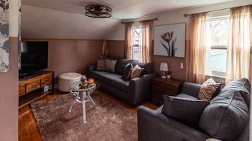 Un salon confortable avec un canapé, une table basse en verre et un téléviseur.