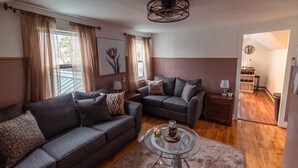 A living room with two sofas, a glass coffee table, and a ceiling fan. - Chic 1-bedroom apartment with WiFi, AC in fabulous Sheboygan (Sheboygan)