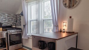 A compact kitchen with a built-in stove, oven, and a small island with shelves. - Chic 1-bedroom apartment with WiFi, AC in fabulous Sheboygan (Sheboygan)