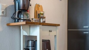 A kitchen with a coffee maker, toaster, and pots on a wooden cart. - Arbio I Spacious Apart near Auensee (Leipzig)