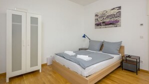 A bedroom with a bed, a wardrobe, a nightstand, and a lamp. - Arbio I Retro Apart near Grassi Museum (Leipzig)