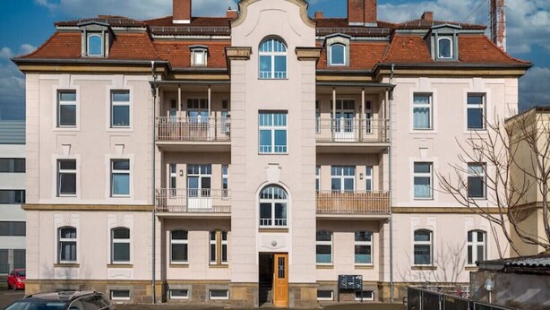 A multi-story building with a symmetrical facade, large windows, and a central entrance.