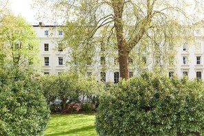 Un grand immeuble à étages, doté d’un jardin bien entretenu à l’avant.
