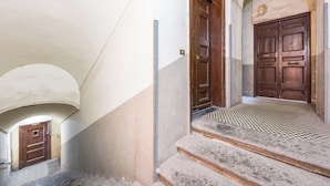 Un escalier menant à une porte en bois, avec un sol à carreaux.