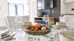 A dining table set with plates, bowls, and glasses, with a decorative bowl in the center. - Blissful Bradford Apartment - City Center Gem (Bradford)