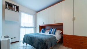 Ein Schlafzimmer mit Bett, Kleiderschrank und Fenster.