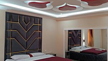 A modern bedroom with a round bed, a large mirror, and a unique ceiling design.