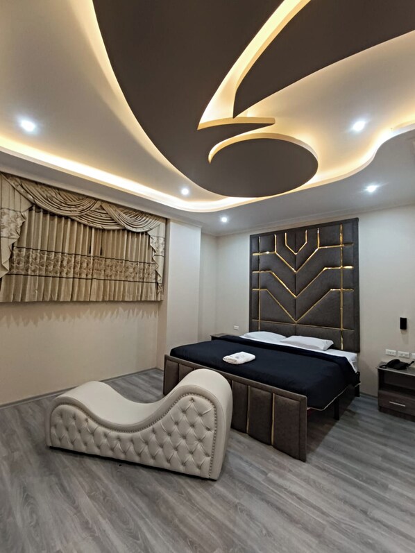 A modern bedroom with a bed, a headboard with geometric patterns, a tufted headboard, and a wall-mounted light fixture.