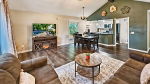 Un salón amplio con chimenea, un comedor y una cocina.
