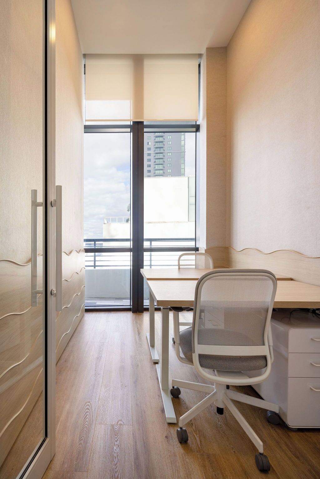 A modern office space with a desk, chair, and filing cabinet.