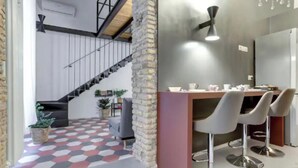 Eine moderne Küche mit Barbereich, einer Treppe und einem geometrisch gemusterten Boden.