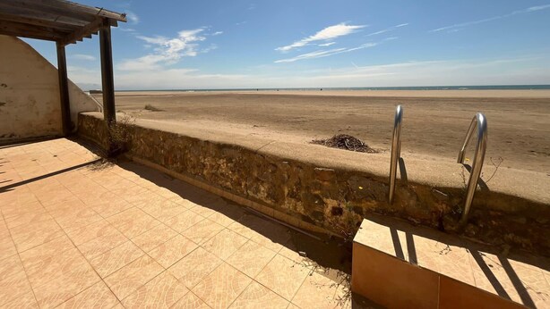 A beach view from a covered area with a tiled floor and metal railings. - House in front of the sea and nature of Fleury (Fleury)