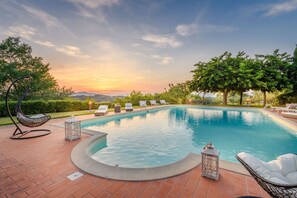 A swimming pool with lounge chairs and a hot tub, surrounded by greenery and a sunset view. - Villa San Miniato in San Miniato (San Miniato)