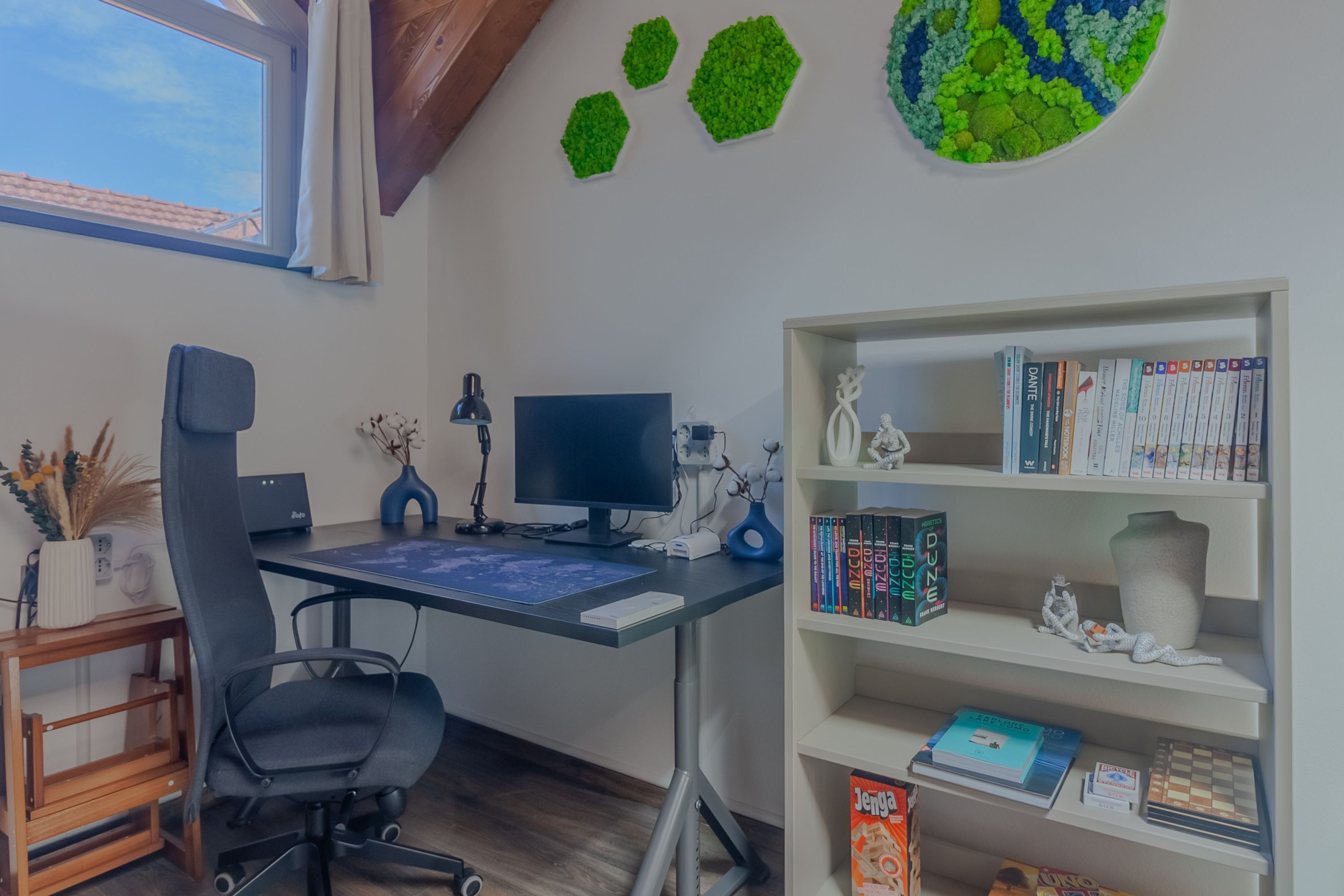 A home office with a desk, computer, and bookshelf.