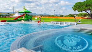Una piscina con tobogán y zona de juegos acuáticos.
