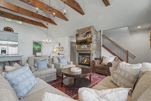 A spacious living room with a fireplace, a dining area, and a kitchen. - Chalet with sweeping mountain views near Blowing Rock and Boone (Blowing Rock)