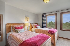 A bedroom with two beds, a wall-mounted lamp, a window with a view, and a motivational poster. - Chalet with sweeping mountain views near Blowing Rock and Boone (Blowing Rock)